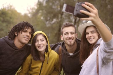 fröhliche Personengruppe im Grünen beim Fotografieren