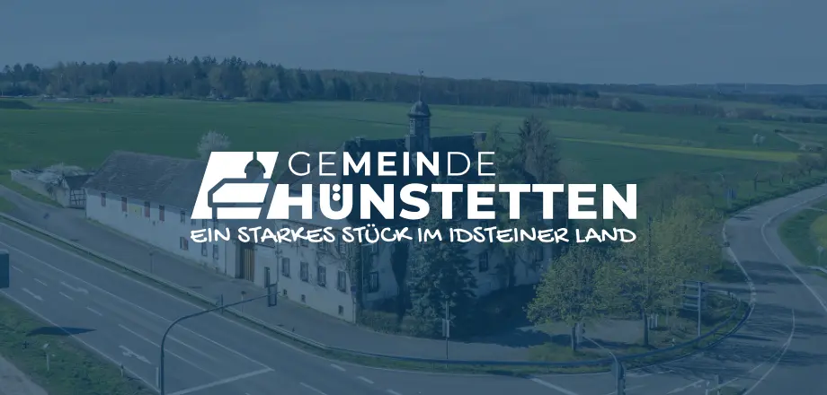 Im Hintergrund die Hühnerkirche, im Vordergrund das Gemeindelogo