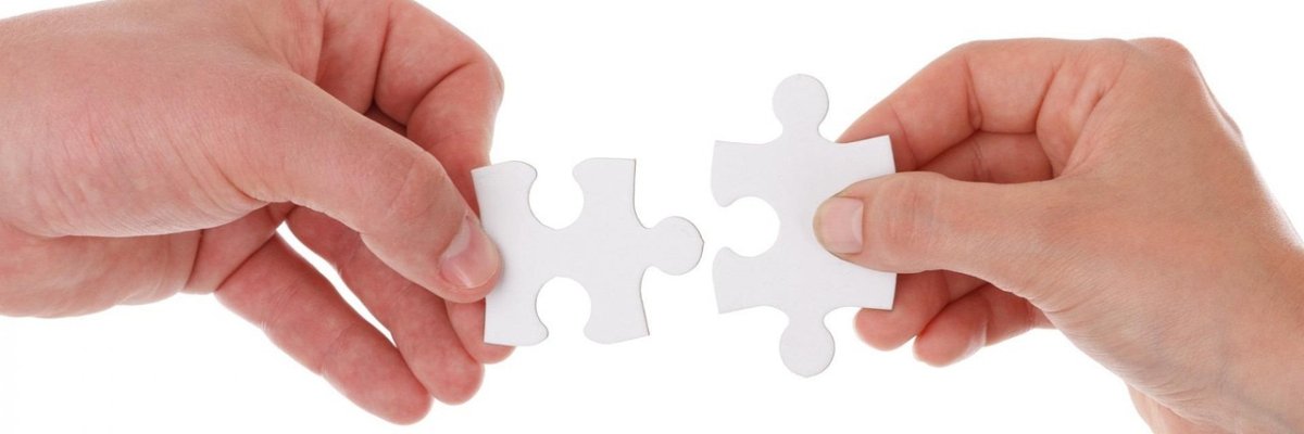 zwei Hände führen jeweils ein weißes Puzzleteil zusammen als Zeichen der Zusammenarbeit